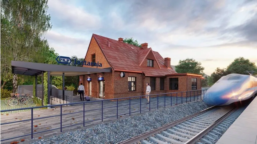 Jastarnia railway station: a brick building with a pitched roof and a covered platform where passengers are waiting.