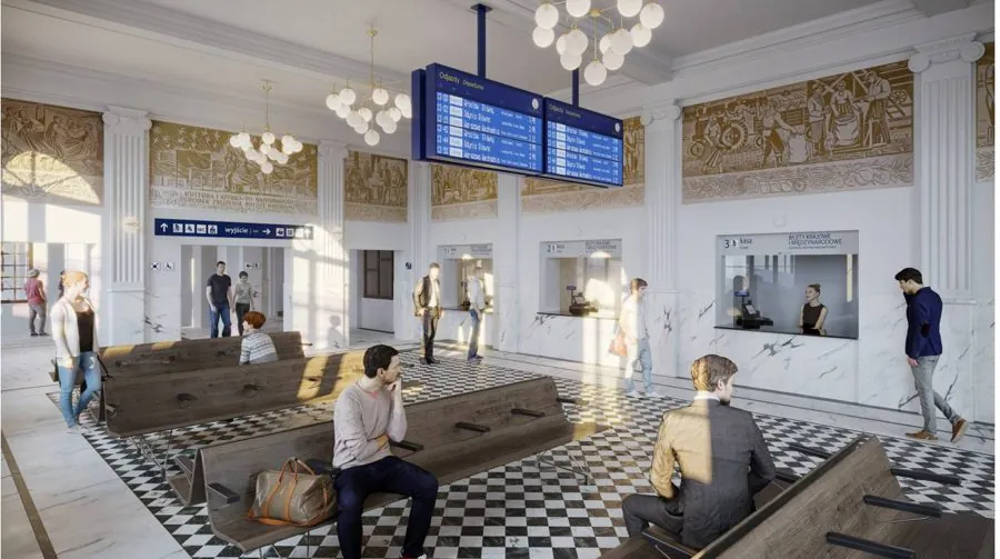 The hall of Skierniewice railway station: ticket counters, departure boards, benches and decorated walls.